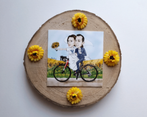 caricatura sposi su bici con campo di girasoli per invito nozze